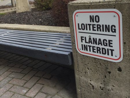 A 'no loitering' sign by a bench in a public space outside the provincial government building on Cedar Street in downtown Sudbury. (Photo by Scott Neigh)