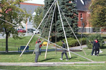 People putting up the teepee in Memorial Park. (Photo by Larson Heinonen)