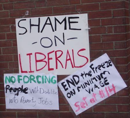 Signs taped to the wall outside the office of Sudbury Liberal MPP Rick Bartolucci during the Solidarity Against Austerity action in Sudbury, Ontario on April 12, 2013. (Photo by Scott Neigh)